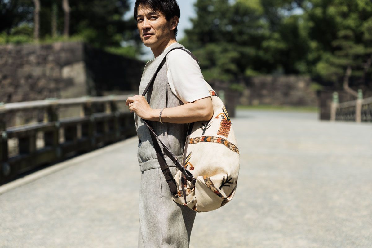 靴179300円、バッグ[W39×H58×D18cm］451000円、ベスト352000円、Tシャツ115500円、パンツ286000円、バングル162800円〈すべてジョルジオ ア ルマーニ／ジョルジオ アルマーニ ジャパン Tel:03-6274-7070〉