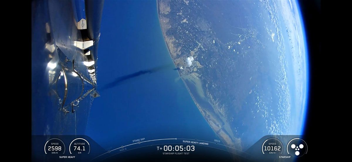 降下するブースター。地表には射場に残る白い噴煙が見える (c)SpaceX