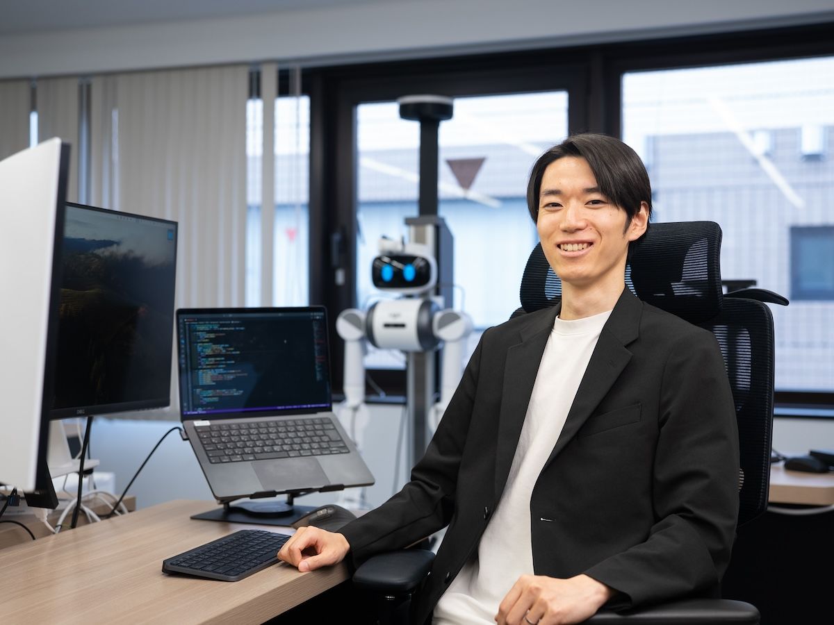 ugo社のセミヒューマノイドと小杉雄斗氏。Prox Industriesは、ugoやUniversal Robotsなどとも連携し、多様なロボットへのフィジカルAI実装と産業応用を推進している。