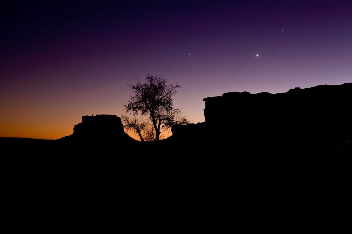 米ニューメキシコ州のチャコ文化国立歴史公園で、夕闇に沈みゆく岩山ファハダ・ビュートの眺めと金星（Jon G. Fuller/VWPics/Universal Images Group via Getty Images）