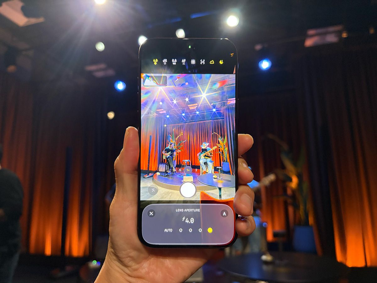 アップルが9月に開催したイベントの取材時に撮影。筆者が手に持っているのがiPhone 18 Pro。レンズの絞り値をF4.0に設定するとスポットライトの強い点光源から放射状の光条が伸びる写真が撮れる