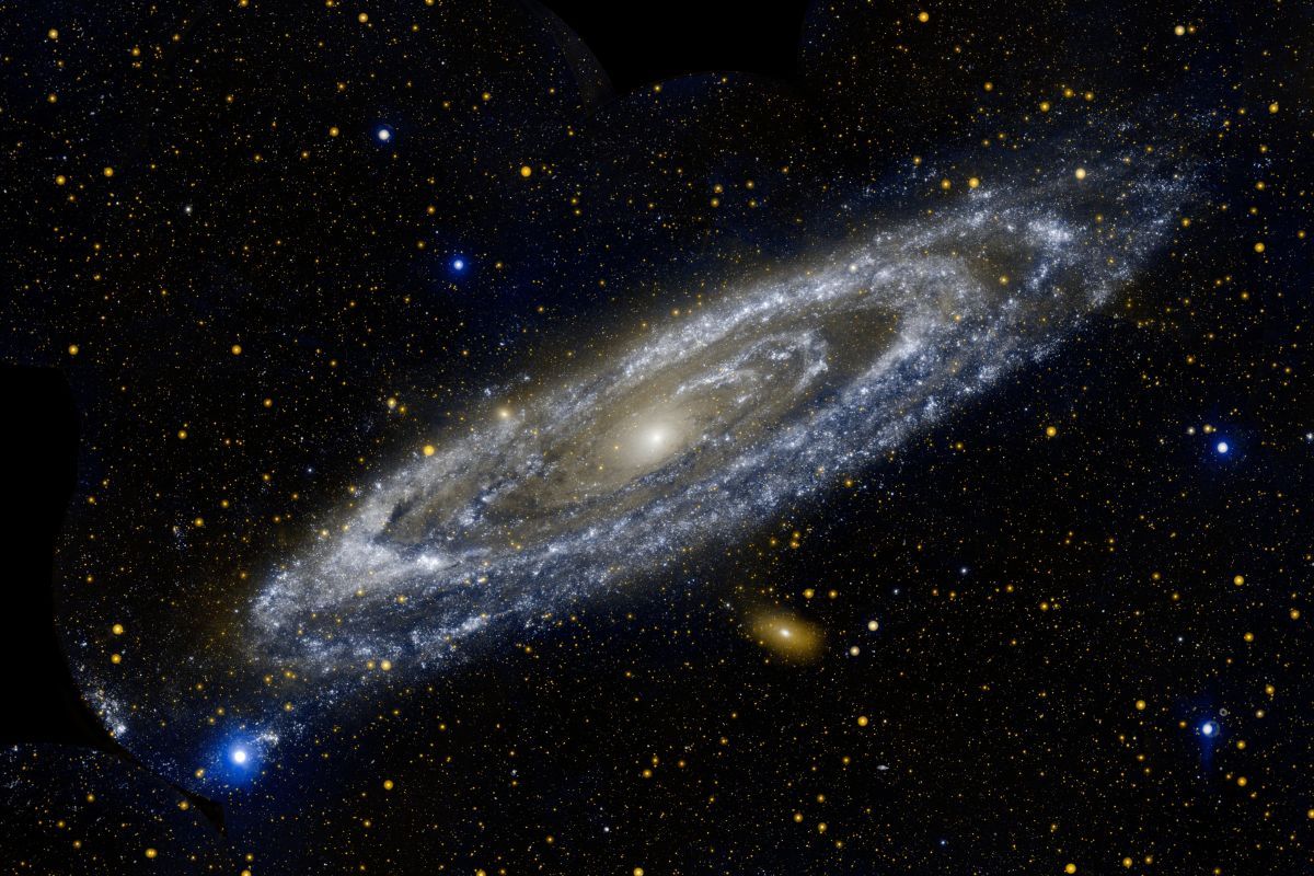 NASAの紫外線観測衛星GALEX（Galaxy Evolution Explorer）が捉えたアンドロメダ銀河（M31）。青色は遠紫外線、オレンジ色は近紫外線を表している（NASA/JPL-Caltech）