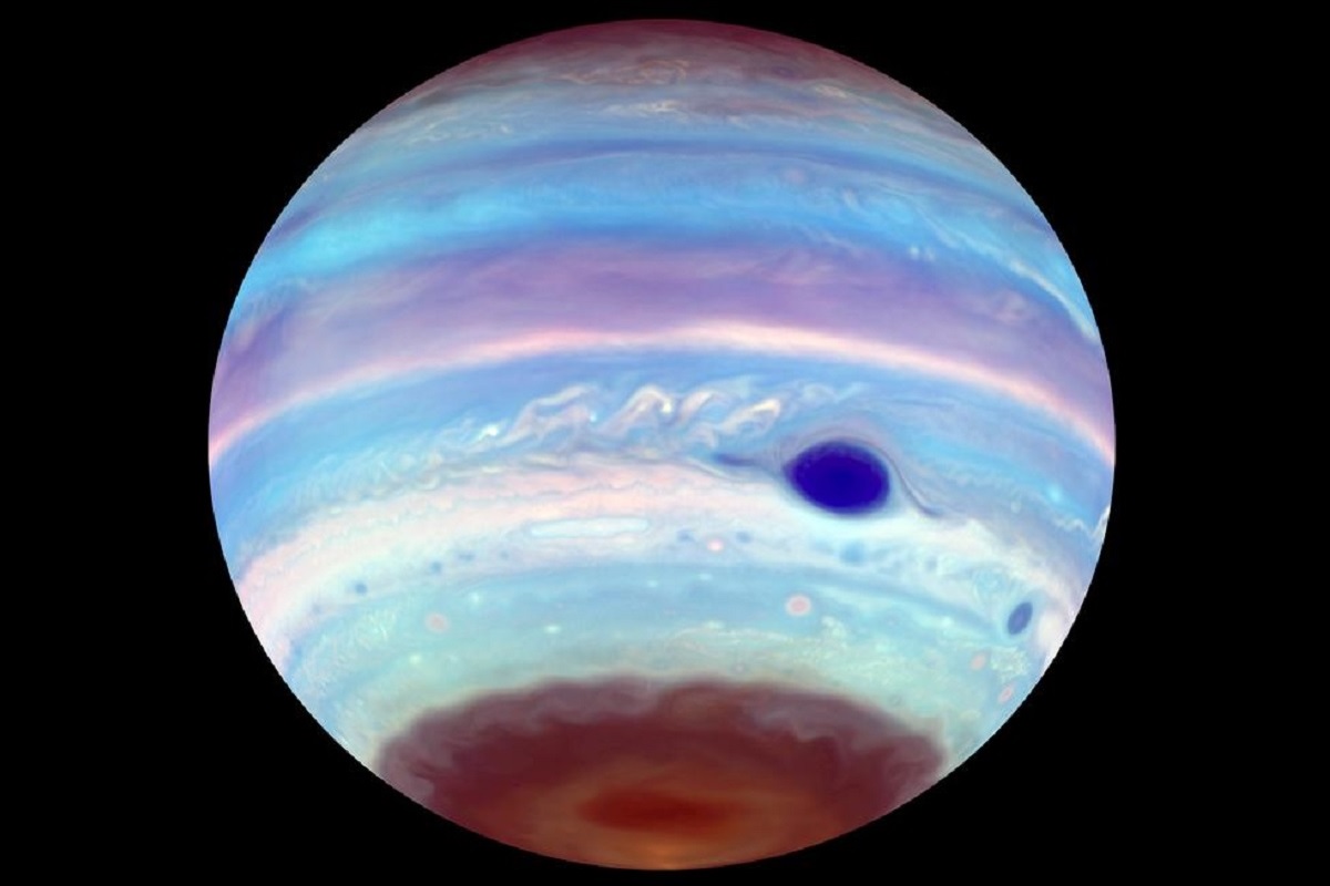 木星の極域に繰り返し出現する「地球サイズの暗斑」の正体、HST画像