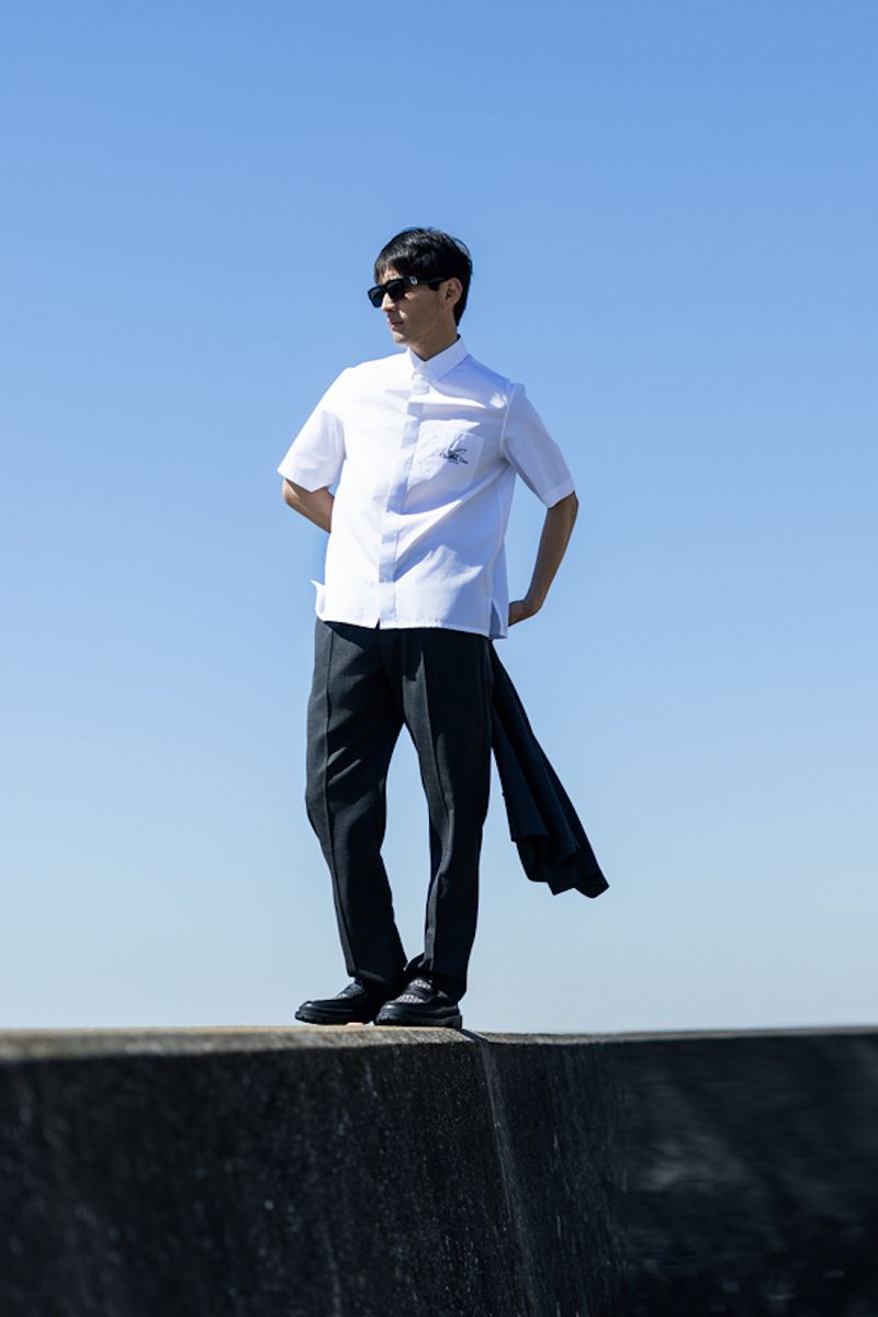 シャツ145000円、パンツ185000円、靴143000円、サングラス78000円、手に持ったジャケット460000円〈すべてディオール／クリスチャン ディオールTel:0120-02-1947〉