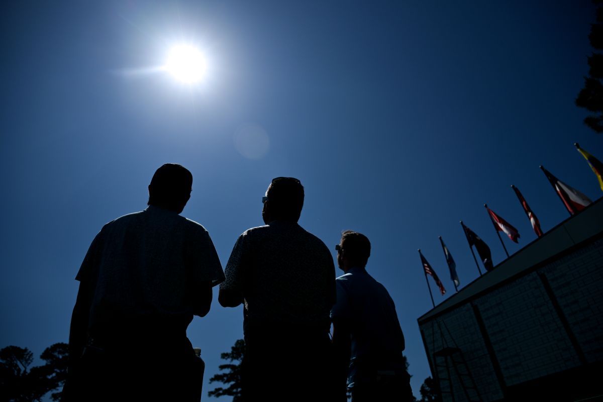 日食グラスを使って太陽を見上げる人々（Ben Jared/PGA TOUR via Getty Images）