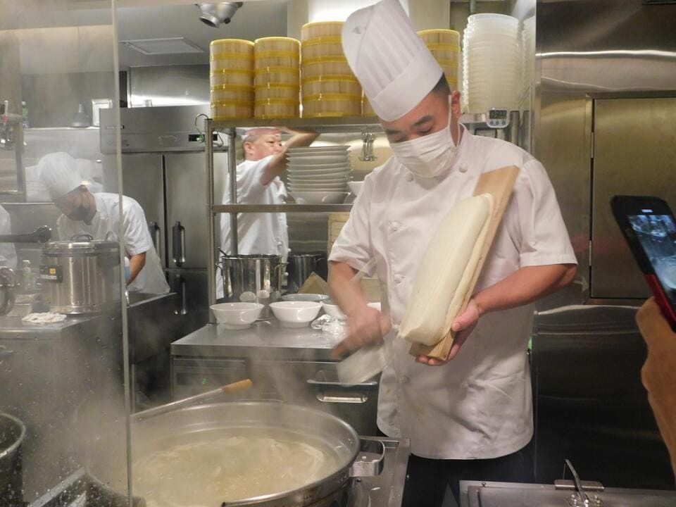 店内のオープンキッチンでは同店の調理人が刀削麺をつくる姿が見られる