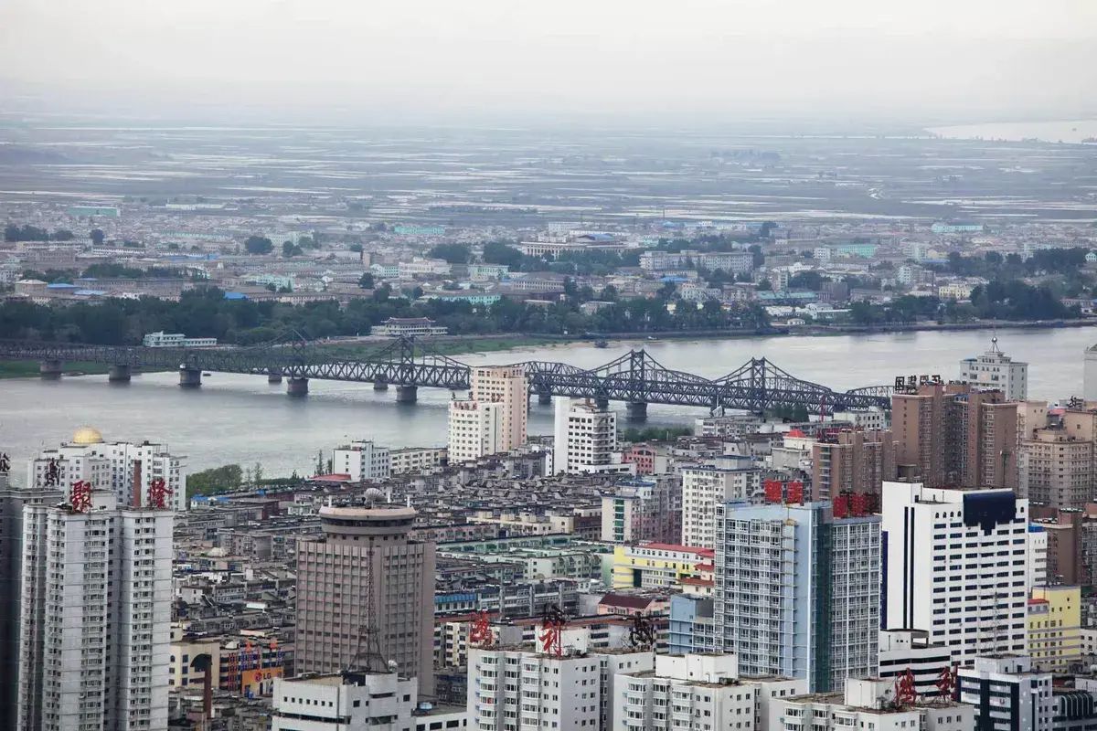 錦江山公園の展望台から眺めた鴨緑江断橋と新義州の町並み（2010年頃の撮影のため、北朝鮮側には高層のビルはないが、現在はいくつかある）