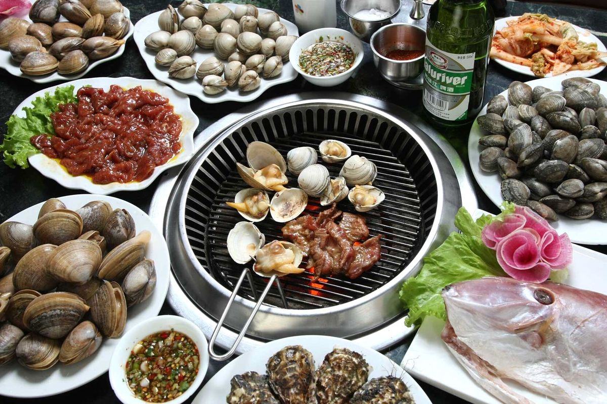 筆者が丹東を訪れるとき、必ず行くのがハマグリBBQの店だ。店に入ると、まず水槽から好みの貝類や魚、肉などを選ぶ。地元産の鴨緑江啤酒（ビール）はコクがあり、飲み応えがある