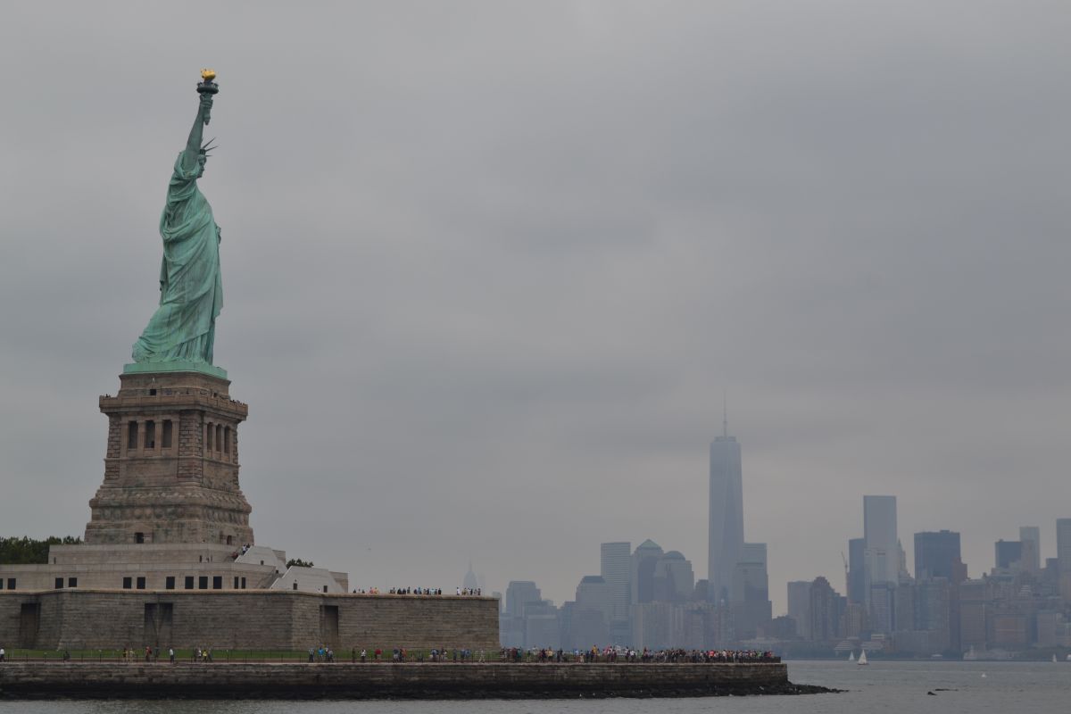 ニューヨークの自由の女神像とマンハッタンの高層ビル（Shutterstock.com）