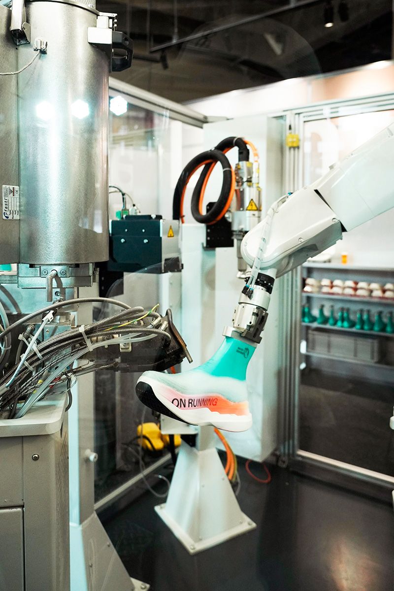 原宿のOn Labs Tokyoで実演されたLightSpray™技術。熱可塑性ポリウレタンのフィラメントをロボットアームが噴射し、わずか3分でアッパーを形成。CO2排出量を従来の製法より75％削減、廃棄物ほぼゼロを実現。