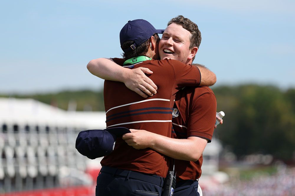 スコットランド 出身のロバート・マッキンタイア（右）は前述のトミー・フリートウッドと歓喜の抱擁。2日目のウェアはメゾンのシグネチャーカラーのクンメルにネイビーとホワイトを配したポロシャツを着用。
