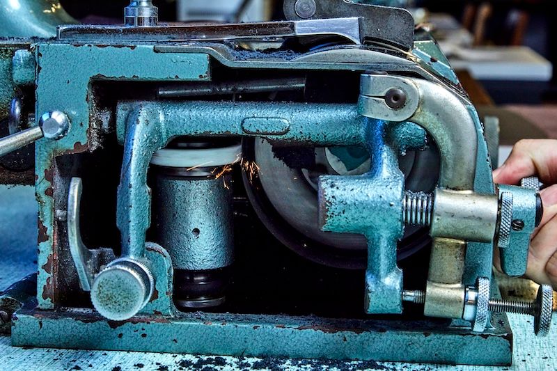 モダンな工場のなかでひときわ目立つ、使い込まれた機械は「革漉き機」。革が重なる部分は厚みが増し全体のフォルムに影響するため、部分的に厚みを調整する必要がある。その革を削ぐ工程を担う。兵庫県にあるニッピ機械の製品。