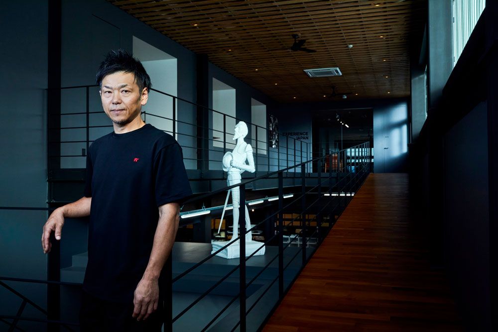 リッツウェル糸島工場 工場長の中村篤矢。後ろにあるのがドン・キホーテの像。