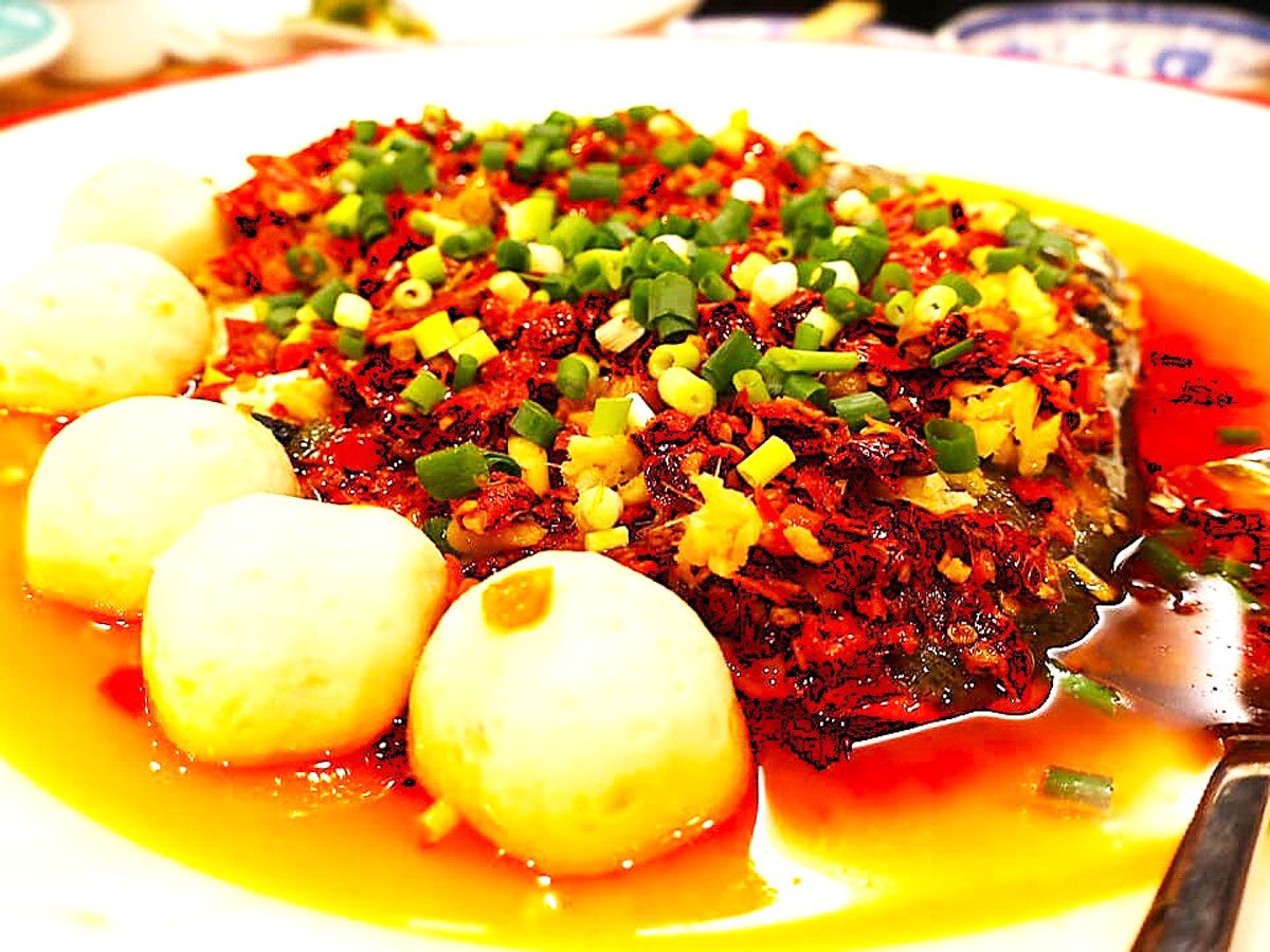 発酵唐辛子がたっぷりとかけられた「魚の頭の発酵唐辛子蒸し（剁椒魚頭）」。現地では川魚が使われるが、この日は中国から輸入した淡水魚のハクレン（花鲢）が使われた