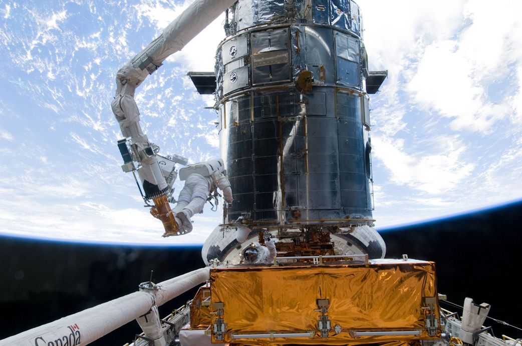 スペースシャトル（アトランティス号）によるハッブルのメンテナンス作業。2009年5月に行われたSTS-125が最後のミッションとなった (c)NASA