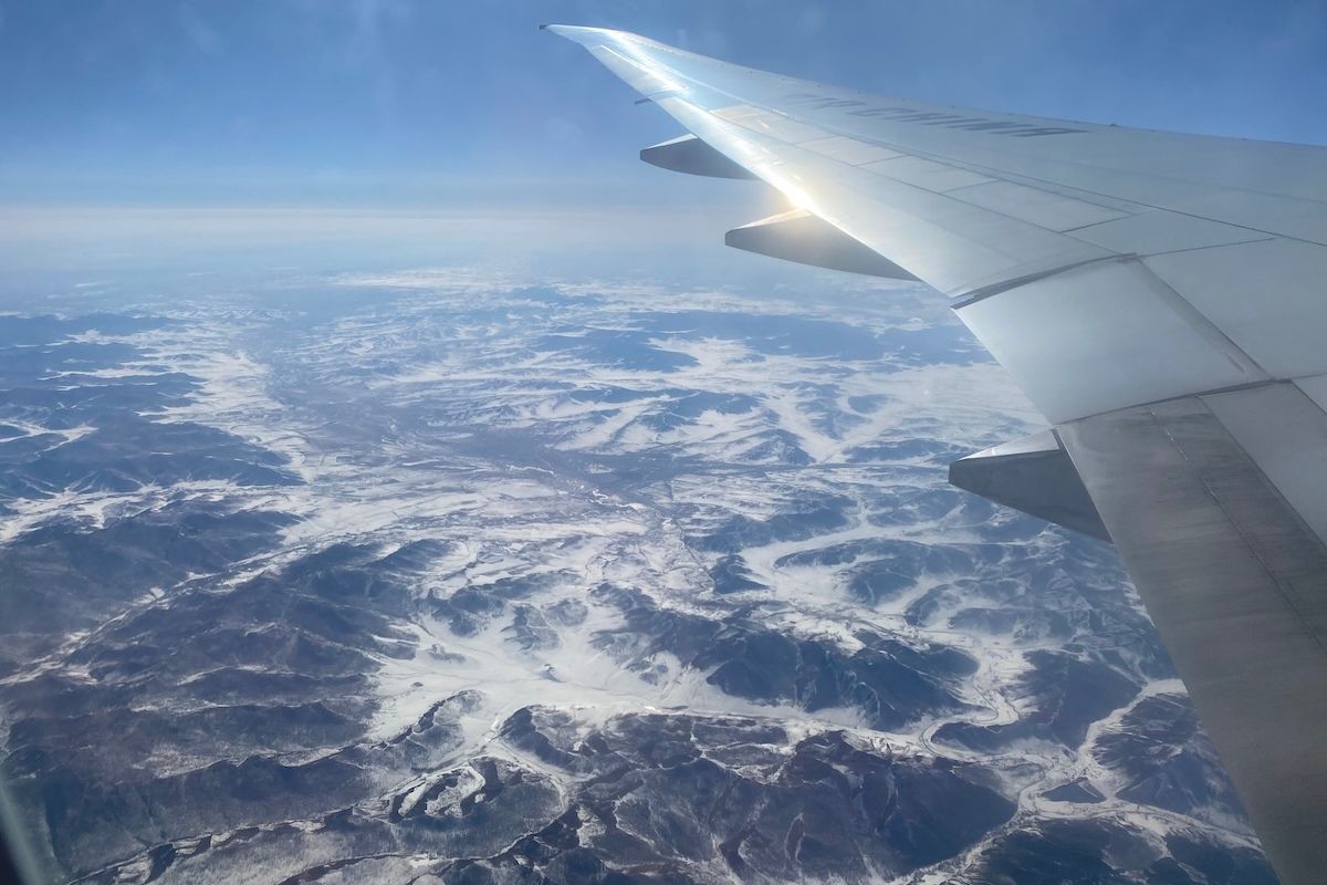 （写真：北極海経由で欧州へ移動中の機内から）