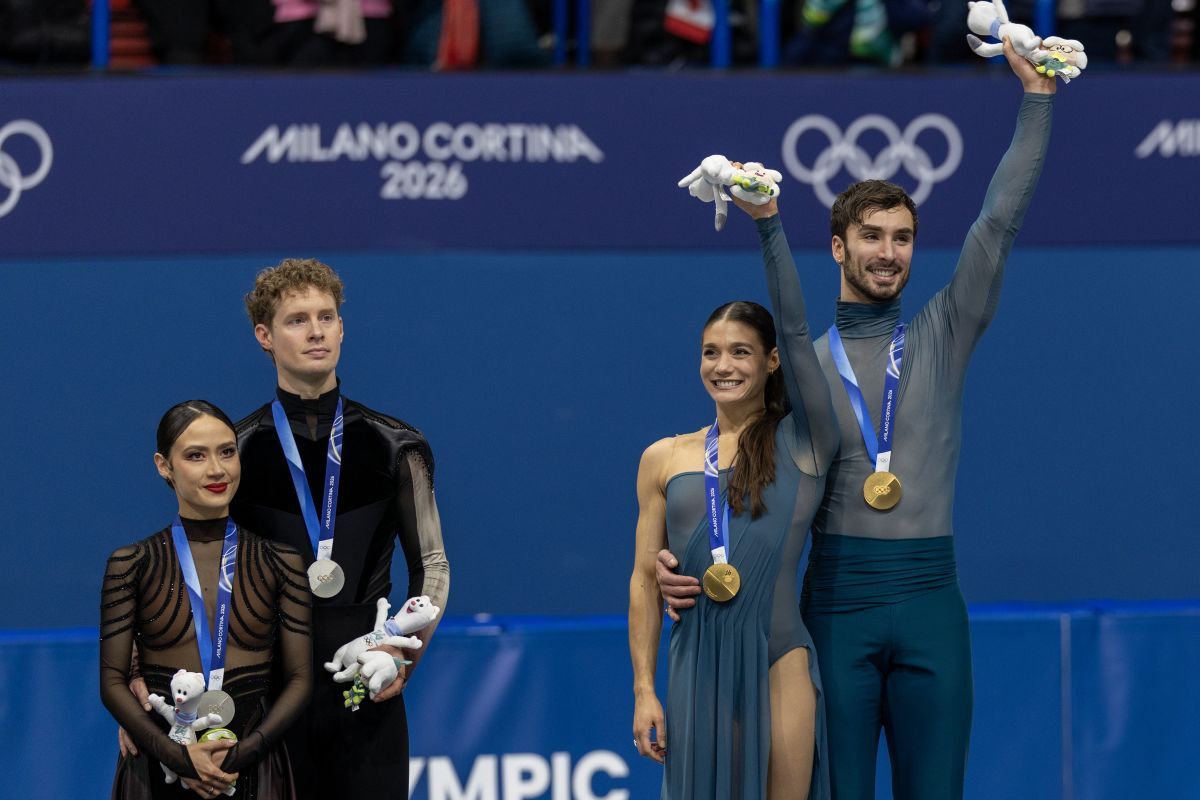 ミラノ・コルティナ冬季五輪フィギュアスケート・アイスダンス表彰式で、表彰台に立つ金メダルを獲得したフランスのロランス・フルニエ・ボードリー／ギヨーム・シゼロン組（右）と、銀メダルに終わった米国のマディソン・チョック／エヴァン・ベイツ組。2026年2月11日、ミラノ・アイススケートアリーナにて（Tim Clayton/Getty Images）