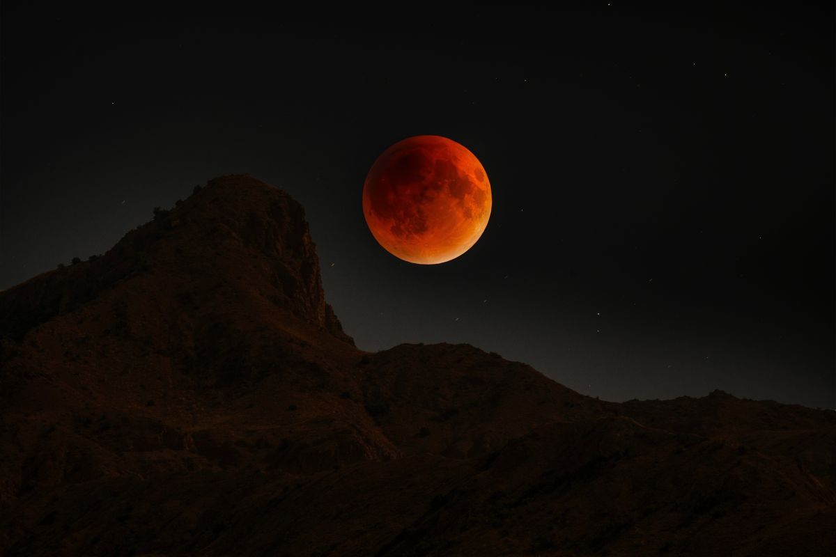 山の上に昇る皆既月食の「ブラッドムーン」（Shutterstock.com）
