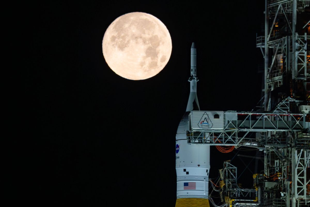 NASA主導の有人月探査計画「アルテミスII」の打ち上げロケット「スペース・ローンチ・システム（SLS）」と宇宙船「オリオン」のそばに輝く満月。米フロリダ州のケネディ宇宙センターにて、2026年2月1日撮影（NASA/Sam Lott）