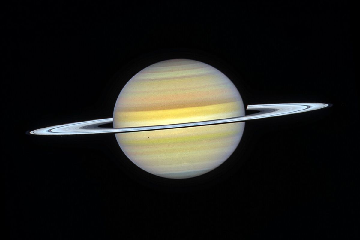 ハッブル宇宙望遠鏡が2024年8月22日に撮影した土星の可視光画像。環の左下側に沿って衛星ヤヌスが、中央左寄りに衛星ミマスの白い点と土星に落ちたその黒い影が、環の右側にヤヌスと公転軌道を共有する衛星エピメテウスが写っている（NASA, ESA, A. Simon (NASA-GSFC), M. Wong (University of California); Image Processing: J. DePasquale (STScI)）