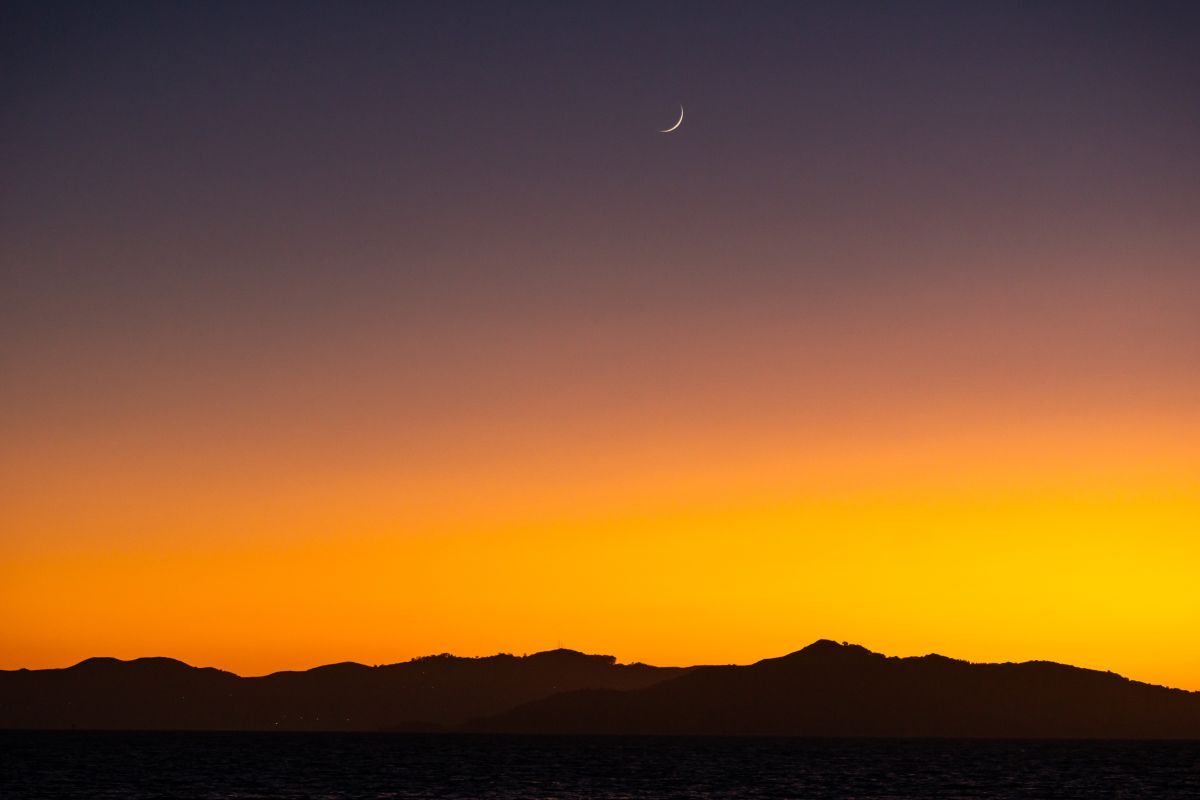 夕焼けの空にかかる新月直後の若い月（stock.adobe.com）