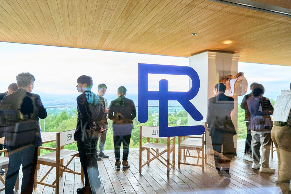眺望のひらけたテラスで交わされる名刺と会話。RLのロゴの向こうに、軽井沢の山並みが静かに広がっていた。