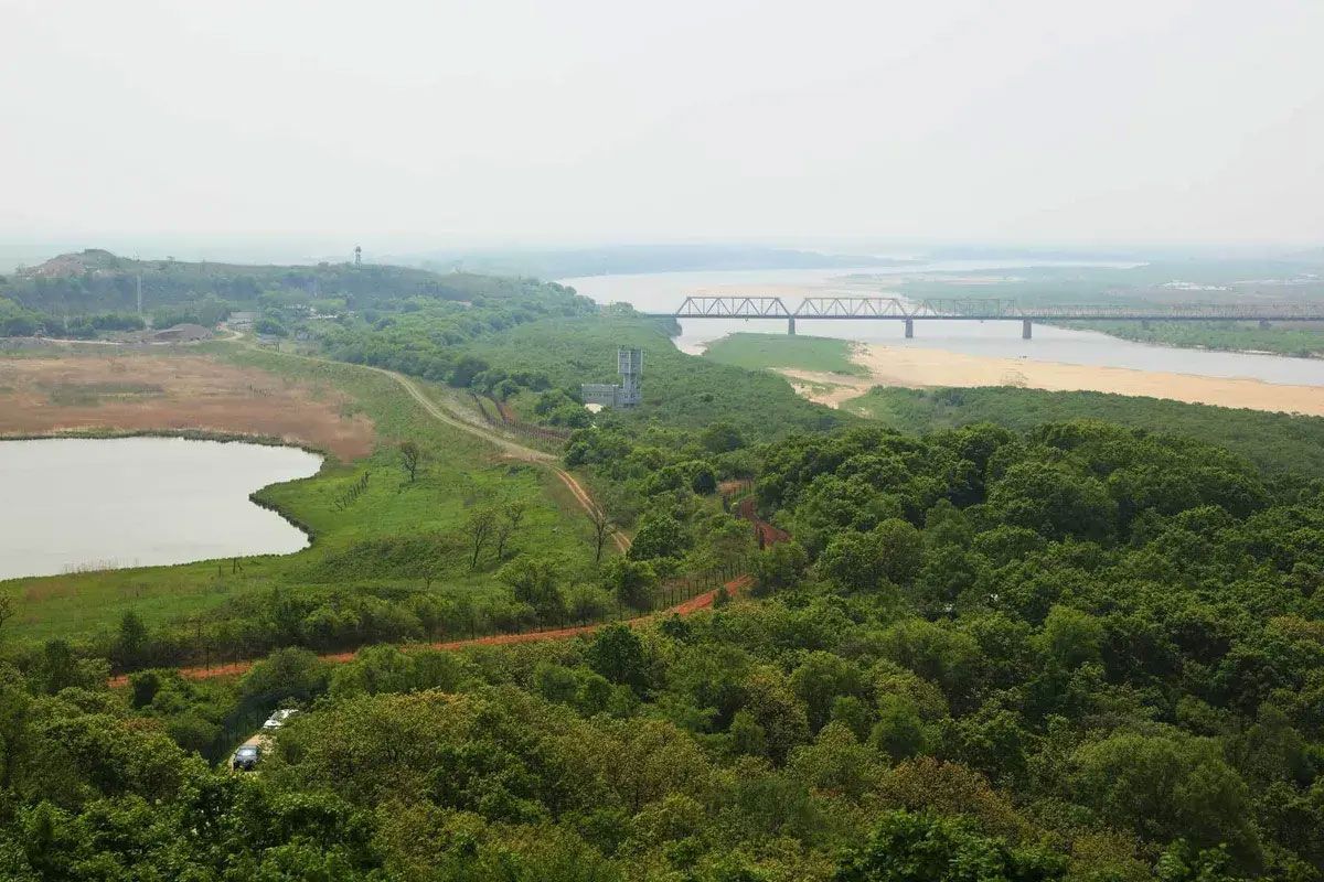 中朝ロ3カ国の国境を中国側の防川展望台から撮影。前方の橋はロシアと北朝鮮をつなぐ鉄道橋で、左側がロシア領、右側が北朝鮮領。中国領は橋の手前までで、日本海に面していない（撮影＝佐藤憲一）