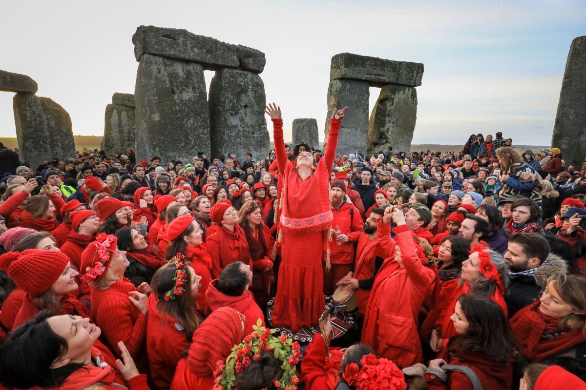 英イングランド・ウィルトシャー州のエイムズベリー近郊にある新石器時代の遺跡ストーンヘンジで、巨石の立ち並ぶ中心に集まって冬至を祝う人々。2018年12月22日撮影（Matt Cardy/Getty Images）